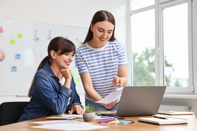 Happy young designers working together in office