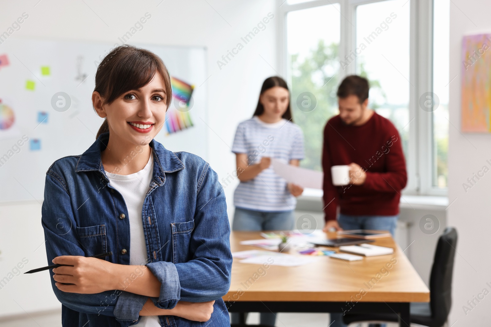 Photo of Portrait of happy young designer in office