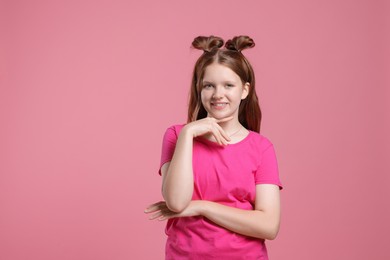 Portrait of teenage girl on pink background, space for text