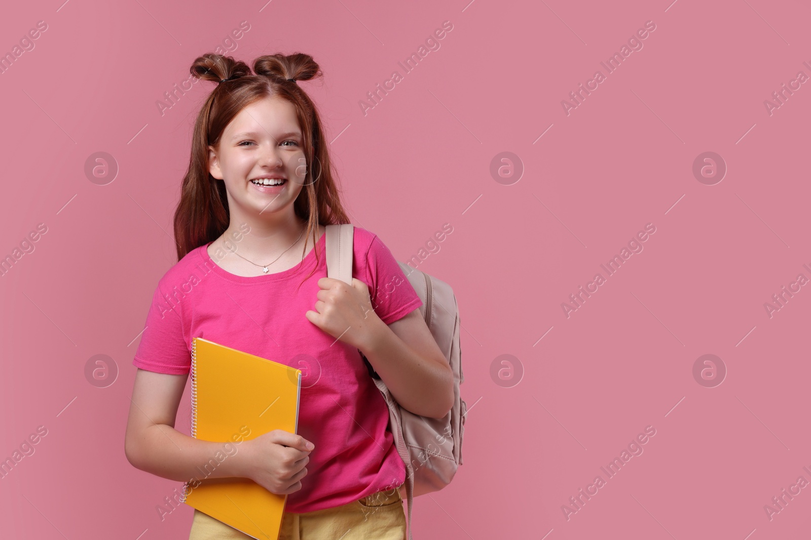 Photo of Teenage girl with backpack and notebook on pink background, space for text