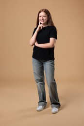 Photo of Full length portrait of teenage girl on beige background