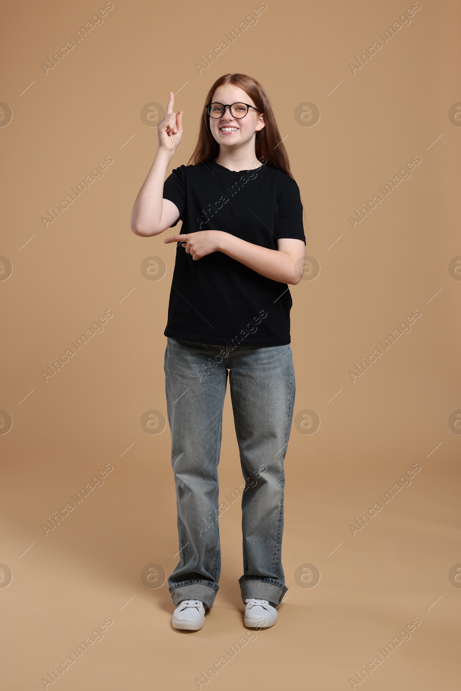 Photo of Full length portrait of teenage girl on beige background