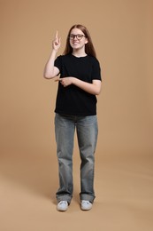 Full length portrait of teenage girl on beige background