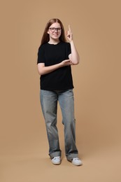 Photo of Full length portrait of teenage girl on beige background