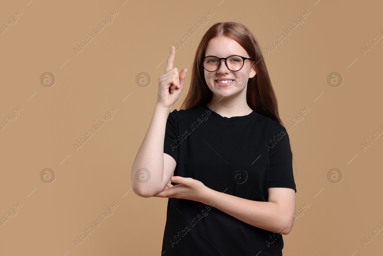 Photo of Portrait of teenage girl on beige background, space for text