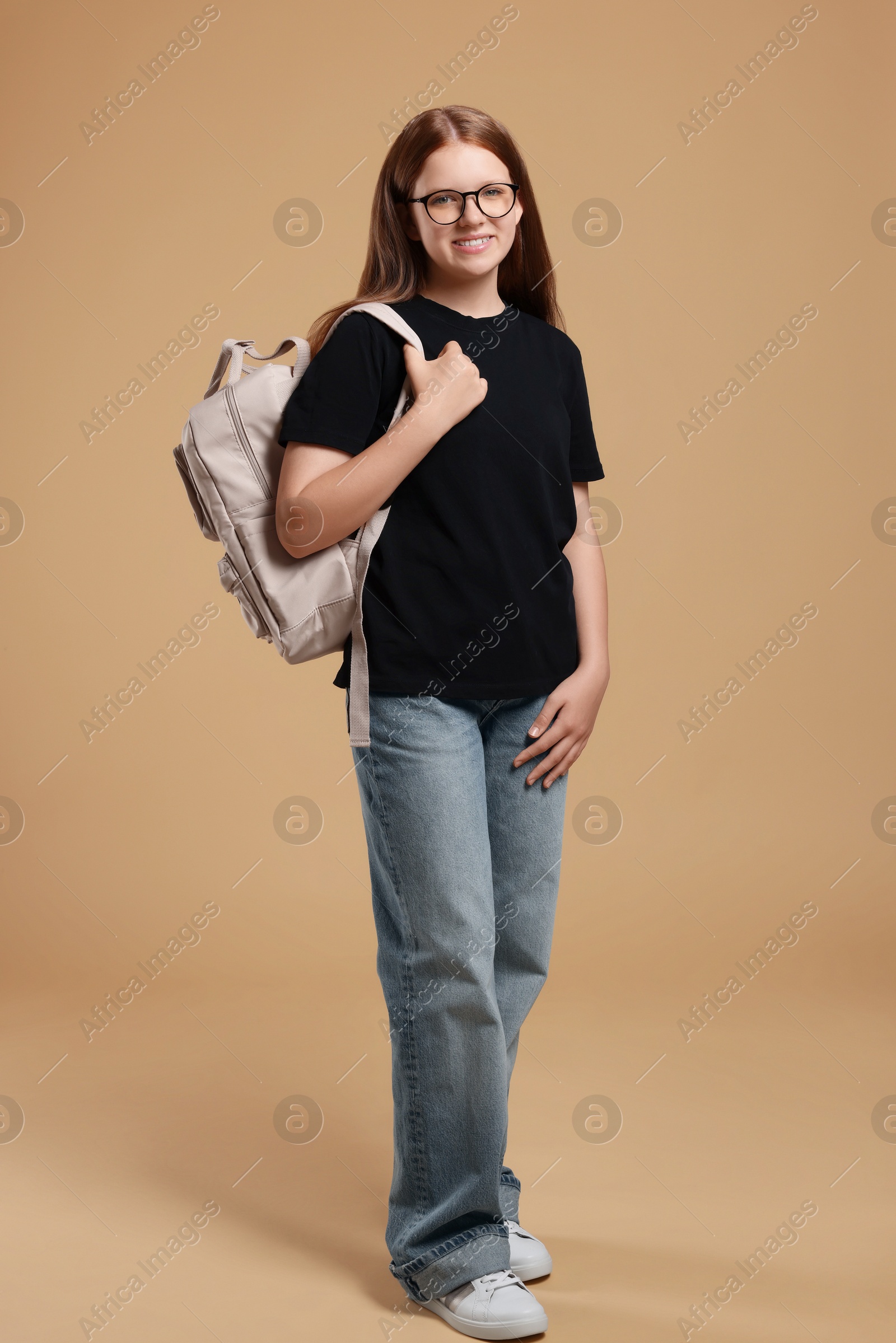 Photo of Teenage girl with backpack on beige background