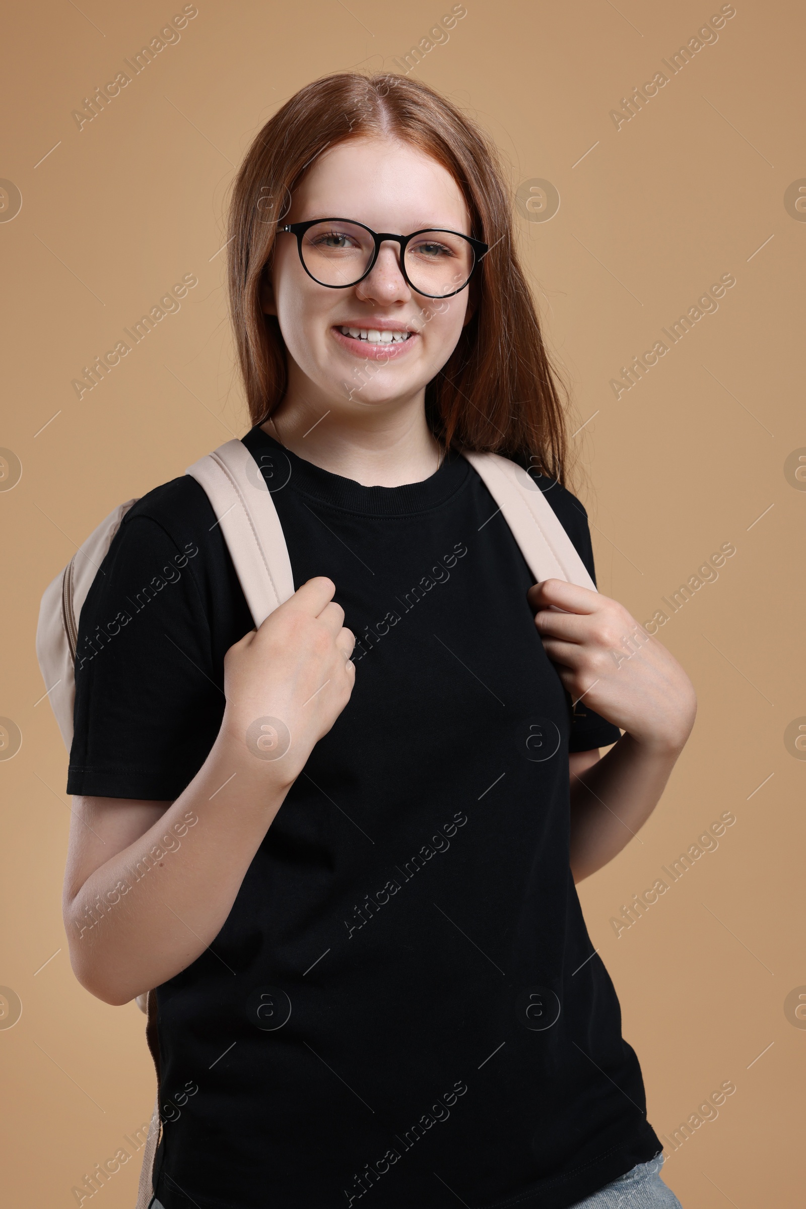 Photo of Teenage girl with backpack on beige background