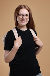 Photo of Teenage girl with backpack on beige background