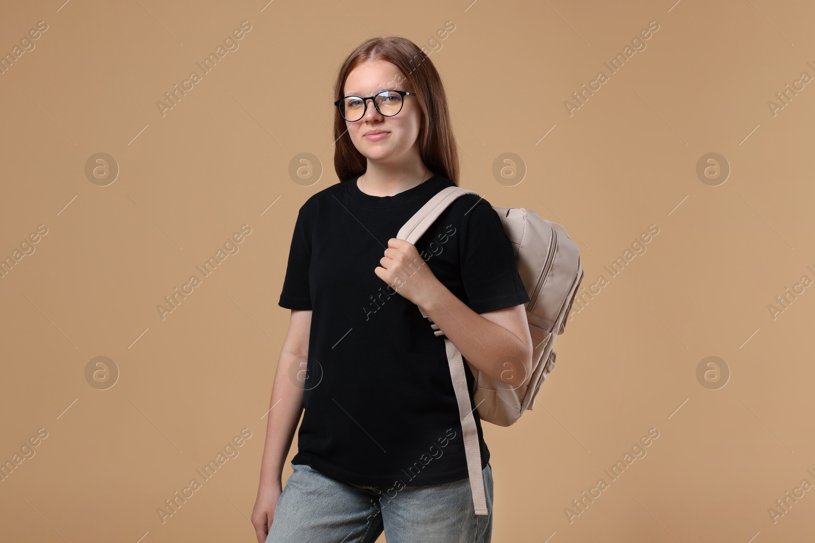 Photo of Teenage girl with backpack on beige background