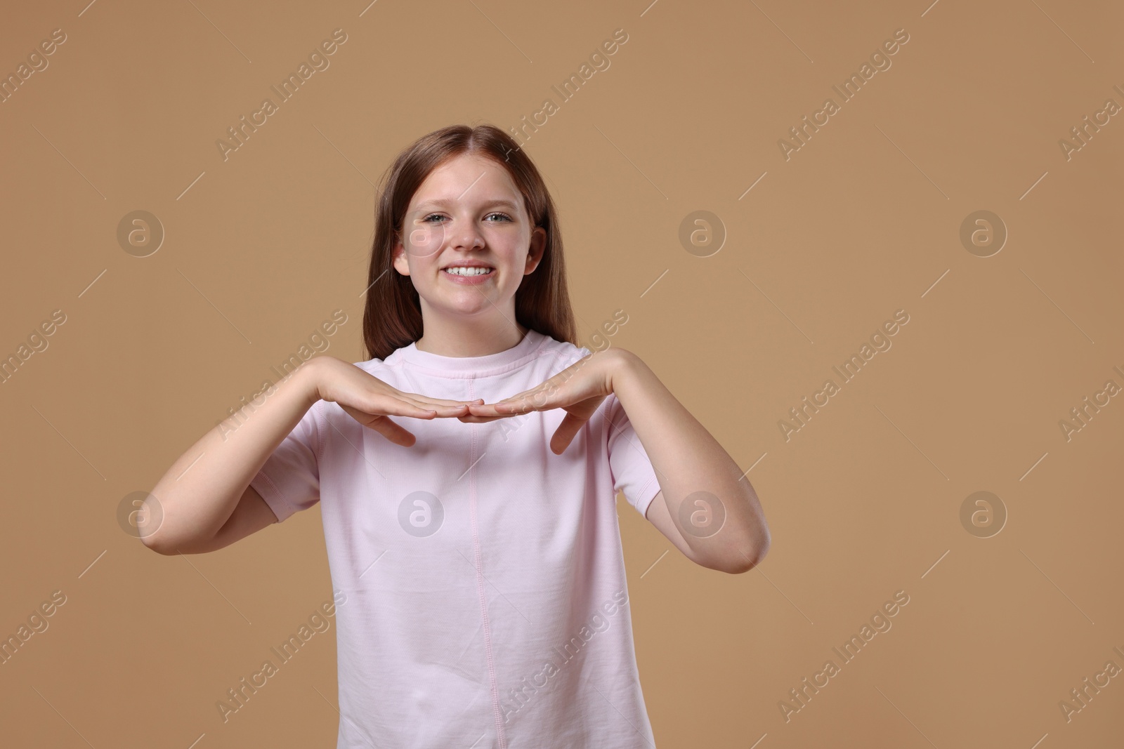 Photo of Portrait of teenage girl on beige background, space for text