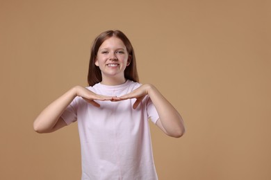 Photo of Portrait of teenage girl on beige background, space for text