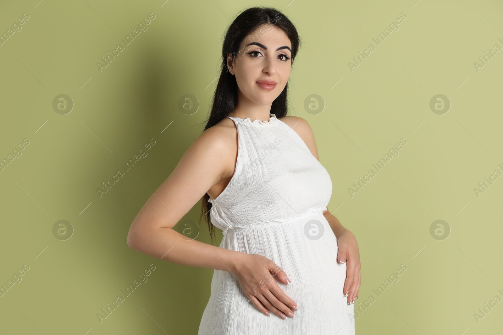 Photo of Portrait of beautiful pregnant woman on light olive background