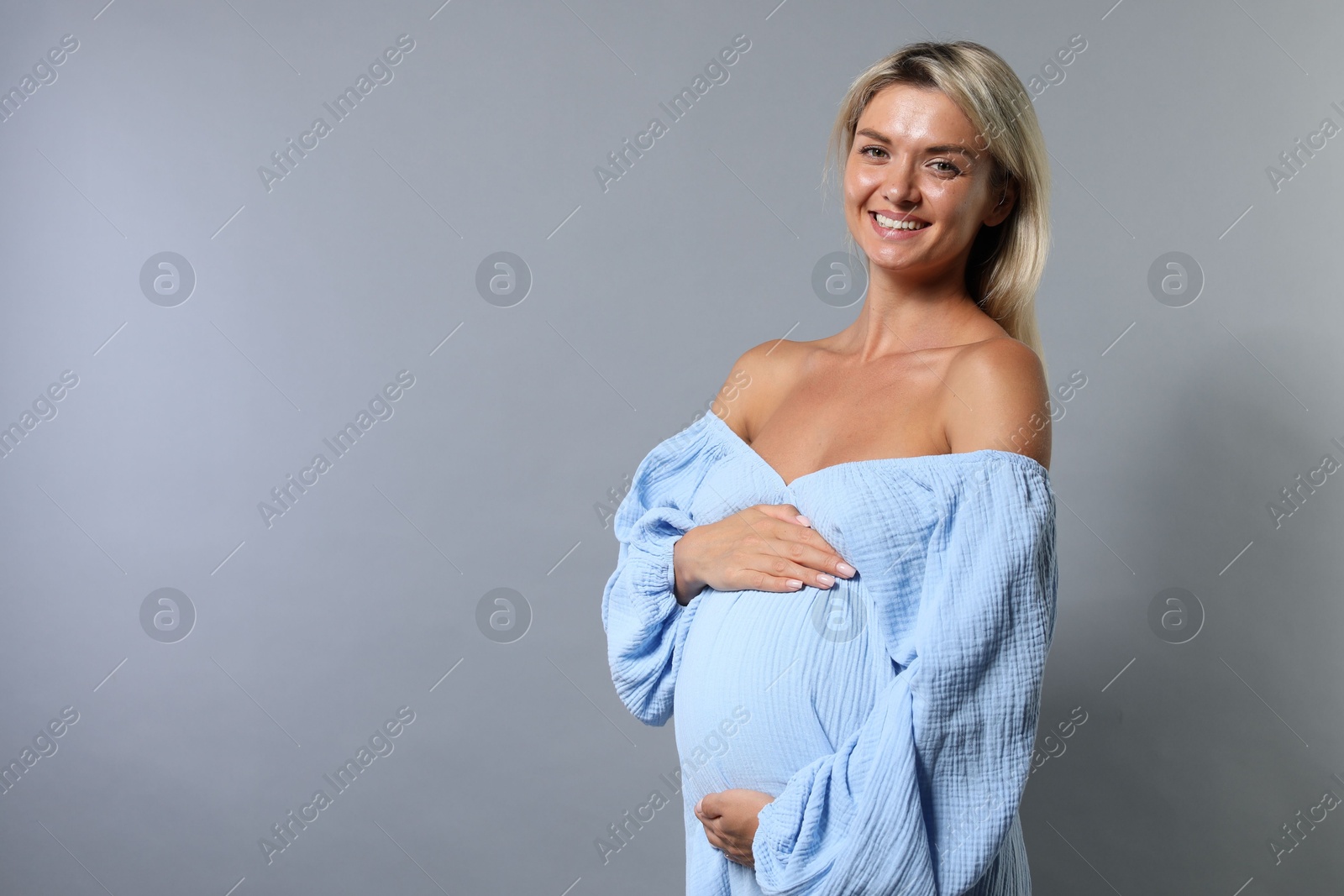 Photo of Portrait of beautiful pregnant woman on grey background, space for text