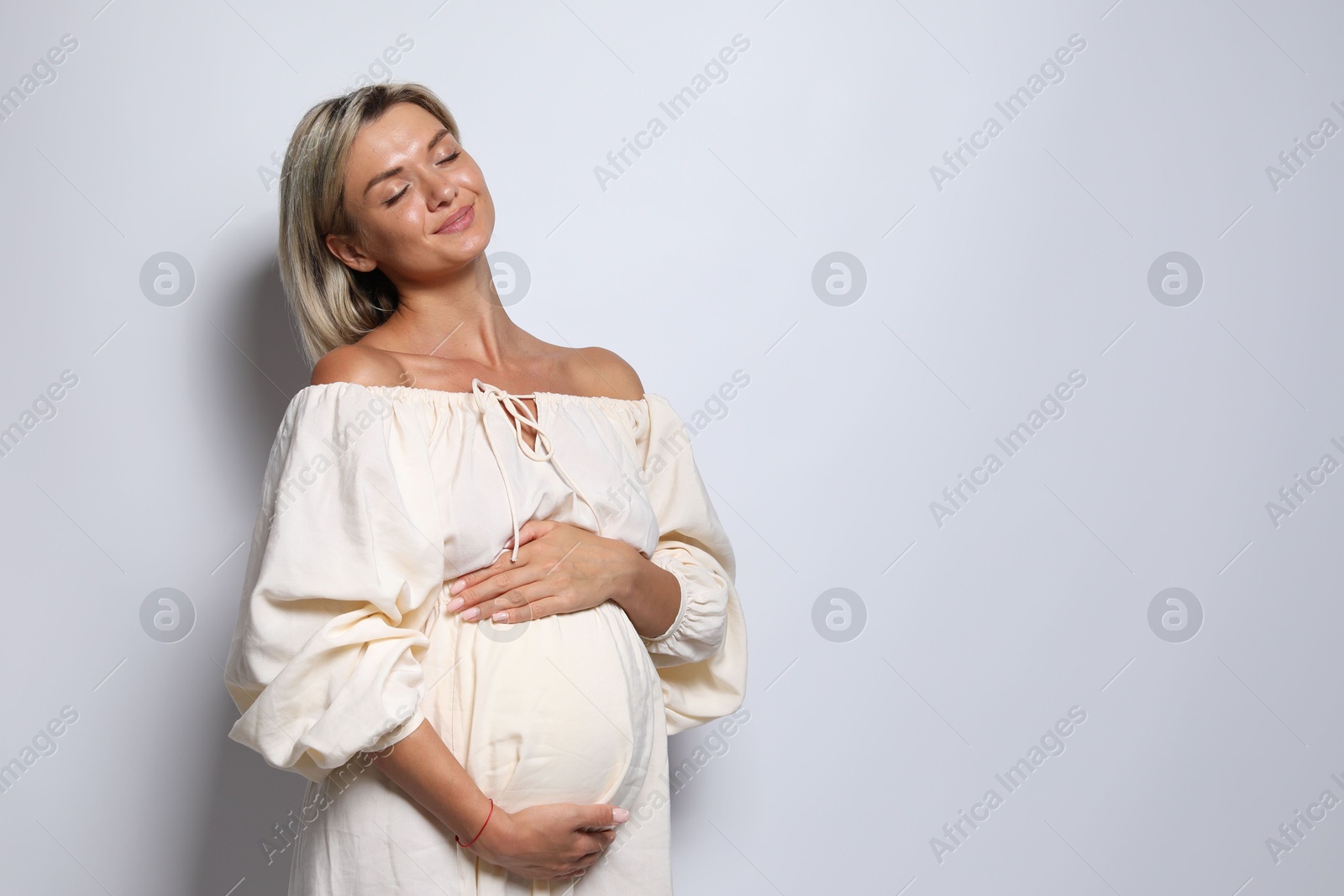 Photo of Portrait of beautiful pregnant woman on white background, space for text