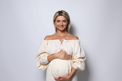 Photo of Portrait of beautiful pregnant woman on white background