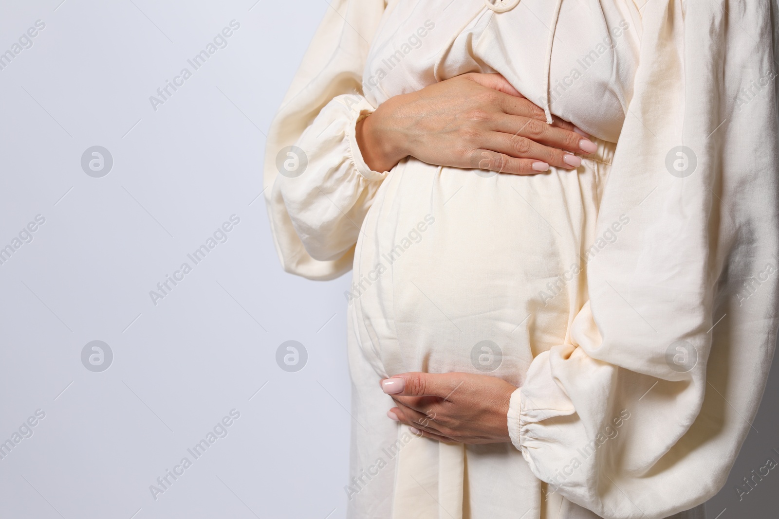 Photo of Pregnant woman on white background, closeup. Space for text