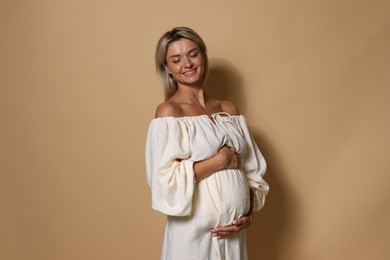 Photo of Portrait of beautiful pregnant woman on beige background