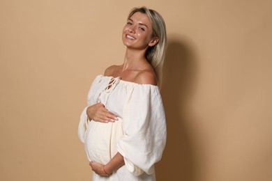 Photo of Portrait of beautiful pregnant woman on beige background