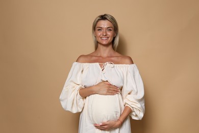 Photo of Portrait of beautiful pregnant woman on beige background