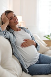 Photo of Portrait of beautiful pregnant woman on sofa at home