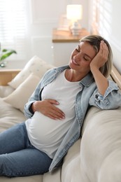 Photo of Portrait of beautiful pregnant woman on sofa at home