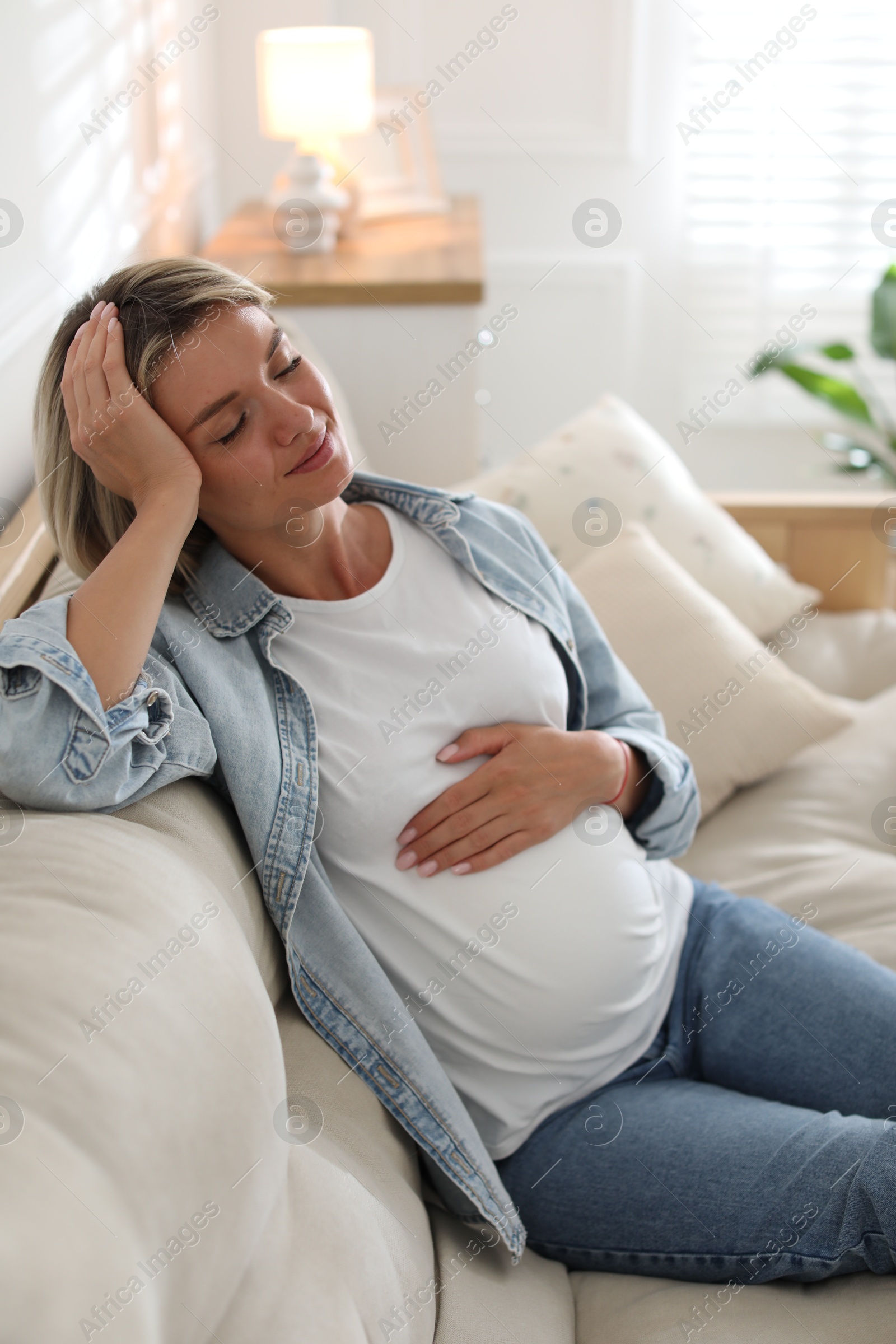 Photo of Portrait of beautiful pregnant woman on sofa at home