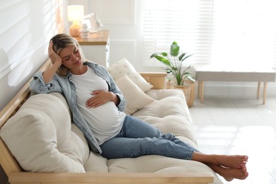 Photo of Portrait of beautiful pregnant woman on sofa at home