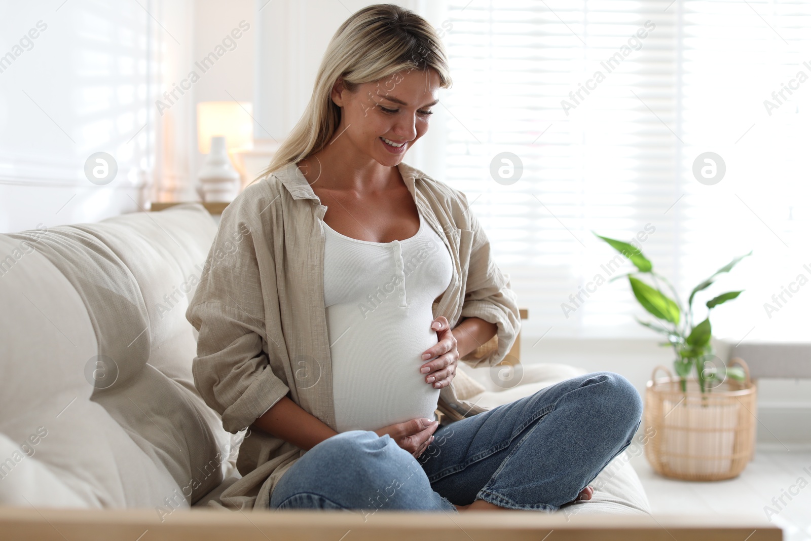 Photo of Portrait of beautiful pregnant woman on sofa at home