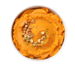 Photo of Delicious mashed sweet potatoes and walnuts in bowl isolated on white, top view