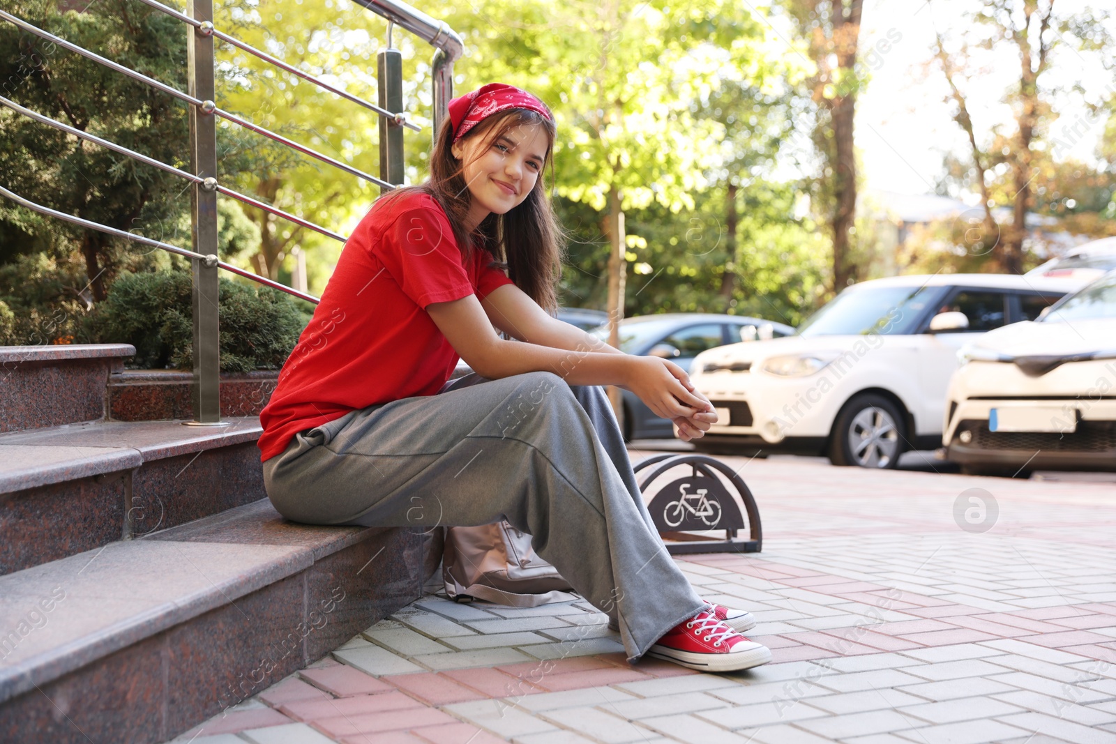 Photo of Cute teenage girl posing on city street