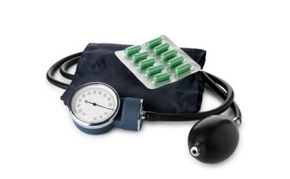 Photo of Blood pressure measuring device and pills in blister isolated on white