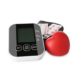 Blood pressure monitor, pills in blisters and red decorative heart isolated on white