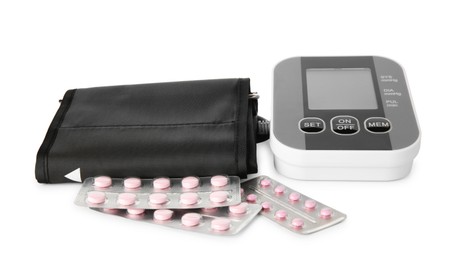 Blood pressure monitor and pills in blisters isolated on white