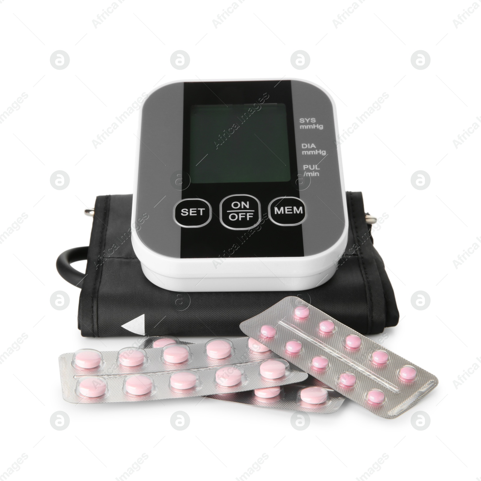 Photo of Blood pressure monitor and pills in blisters isolated on white