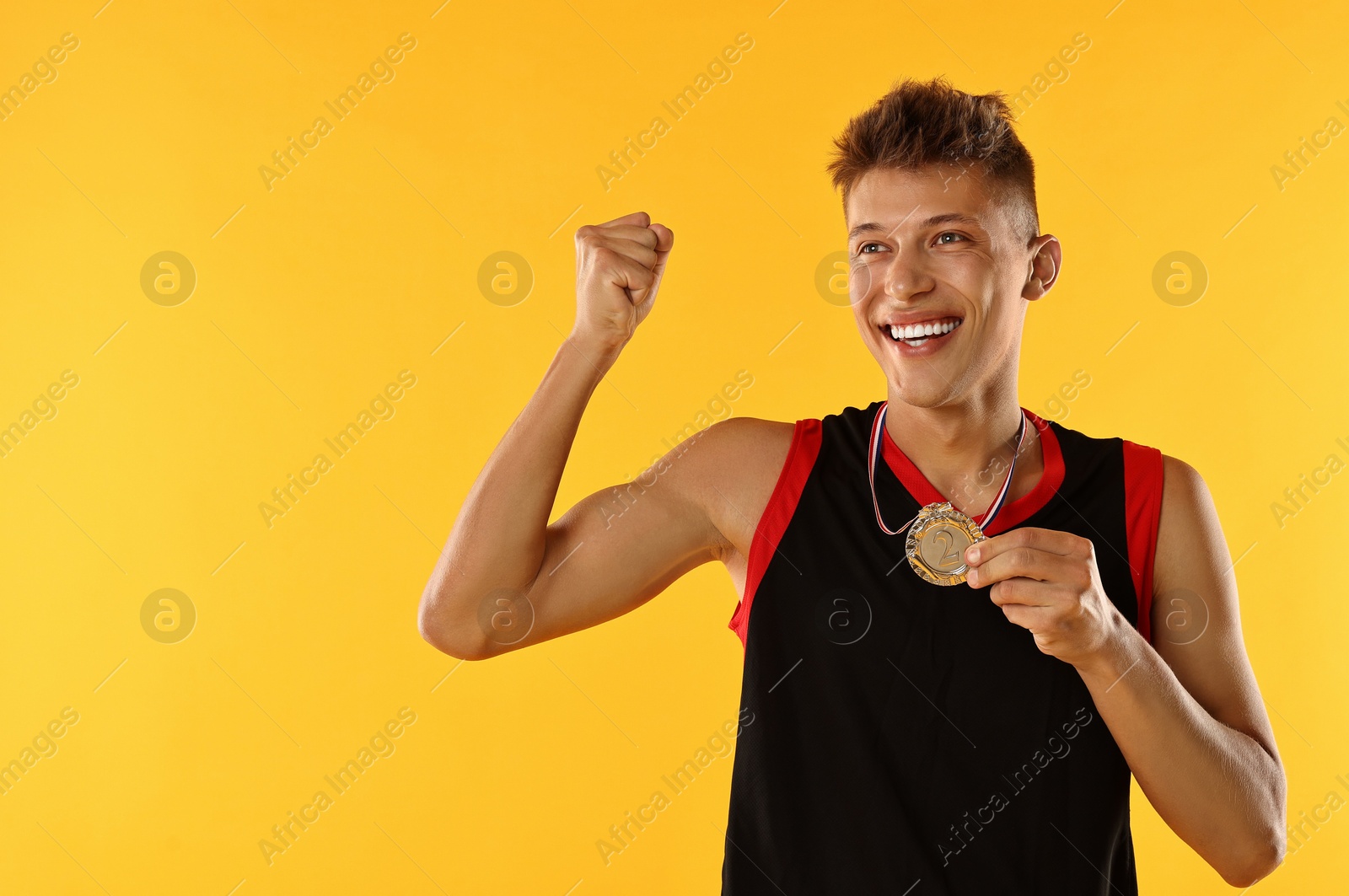 Photo of Happy winner with silver medal on yellow background. Space for text