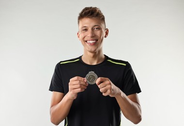 Photo of Happy winner with silver medal on light grey background