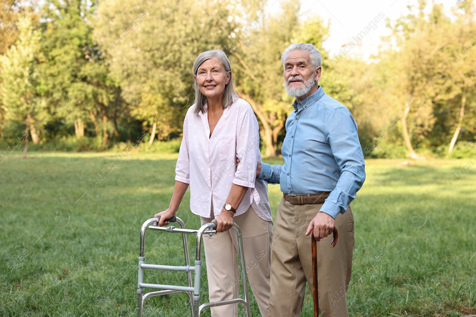 Photo of Senior couple with walking frame and cane in park