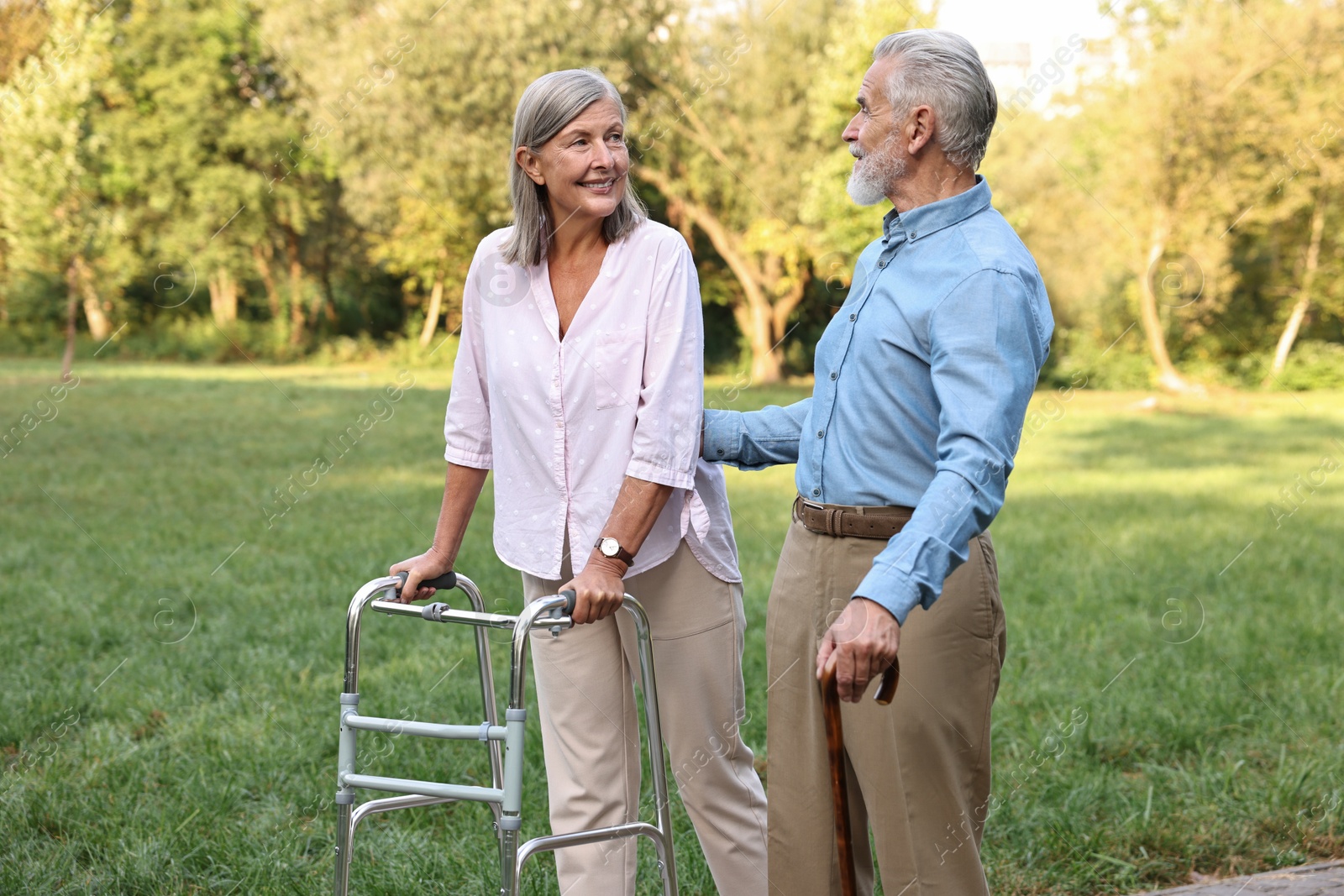 Photo of Senior couple with walking frame and cane in park