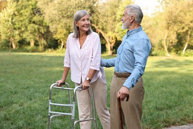 Photo of Senior couple with walking frame and cane in park