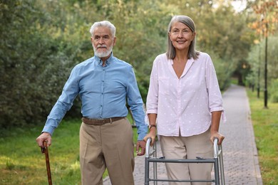 Senior couple with walking frame and cane in park