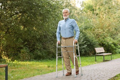 Senior man with walking frame in park