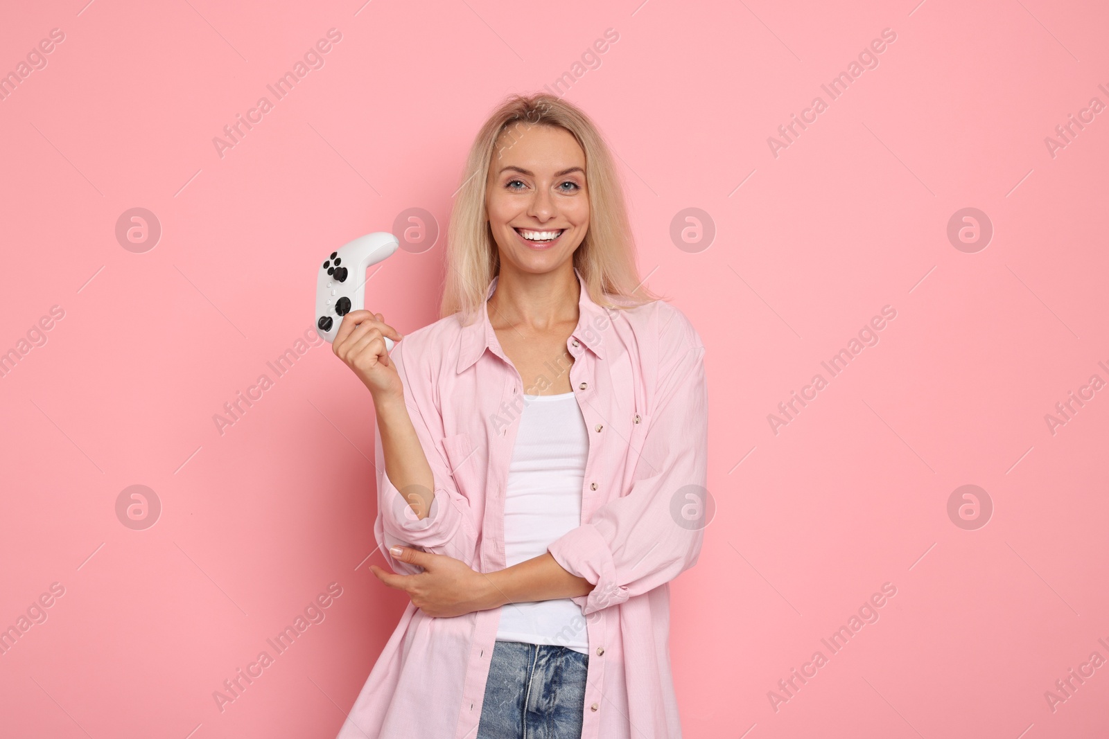 Photo of Happy woman with controller on pink background