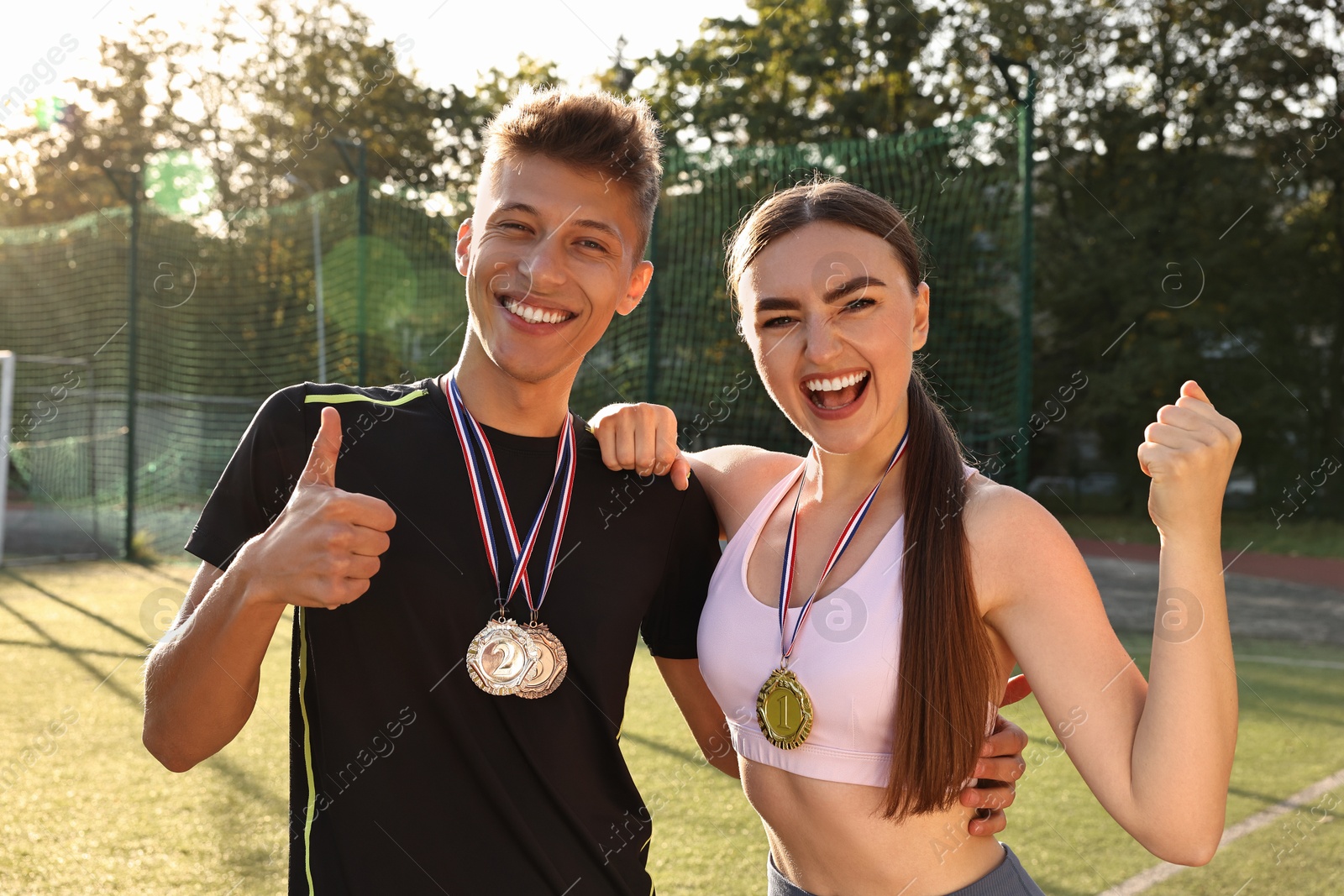 Photo of Portrait of happy winners with medals at stadium