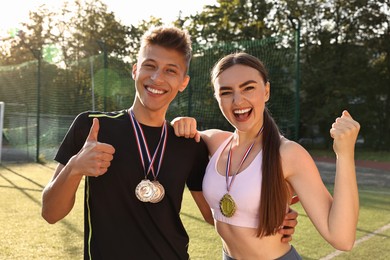 Photo of Portrait of happy winners with medals at stadium