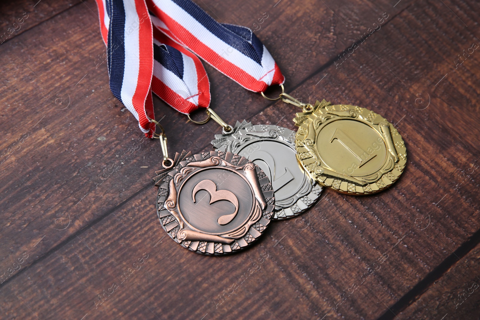 Photo of Golden, silver and bronze medals on wooden background, closeup