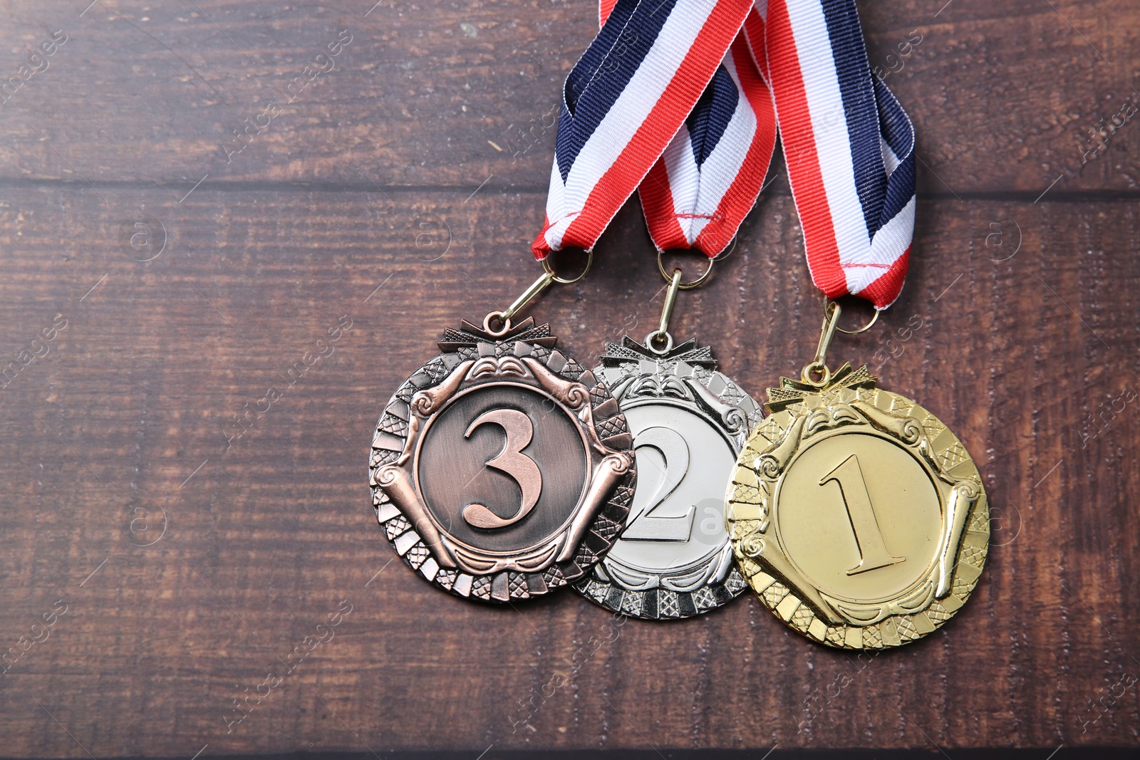 Photo of Golden, silver and bronze medals on wooden background, top view