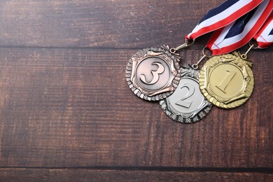 Photo of Golden, silver and bronze medals on wooden background, top view. Space for text