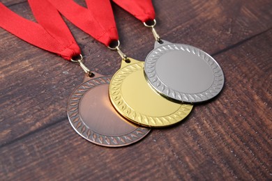 Photo of Golden, silver and bronze medals on wooden background, closeup