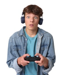 Emotional teenage boy in headphones playing video game with controller on white background