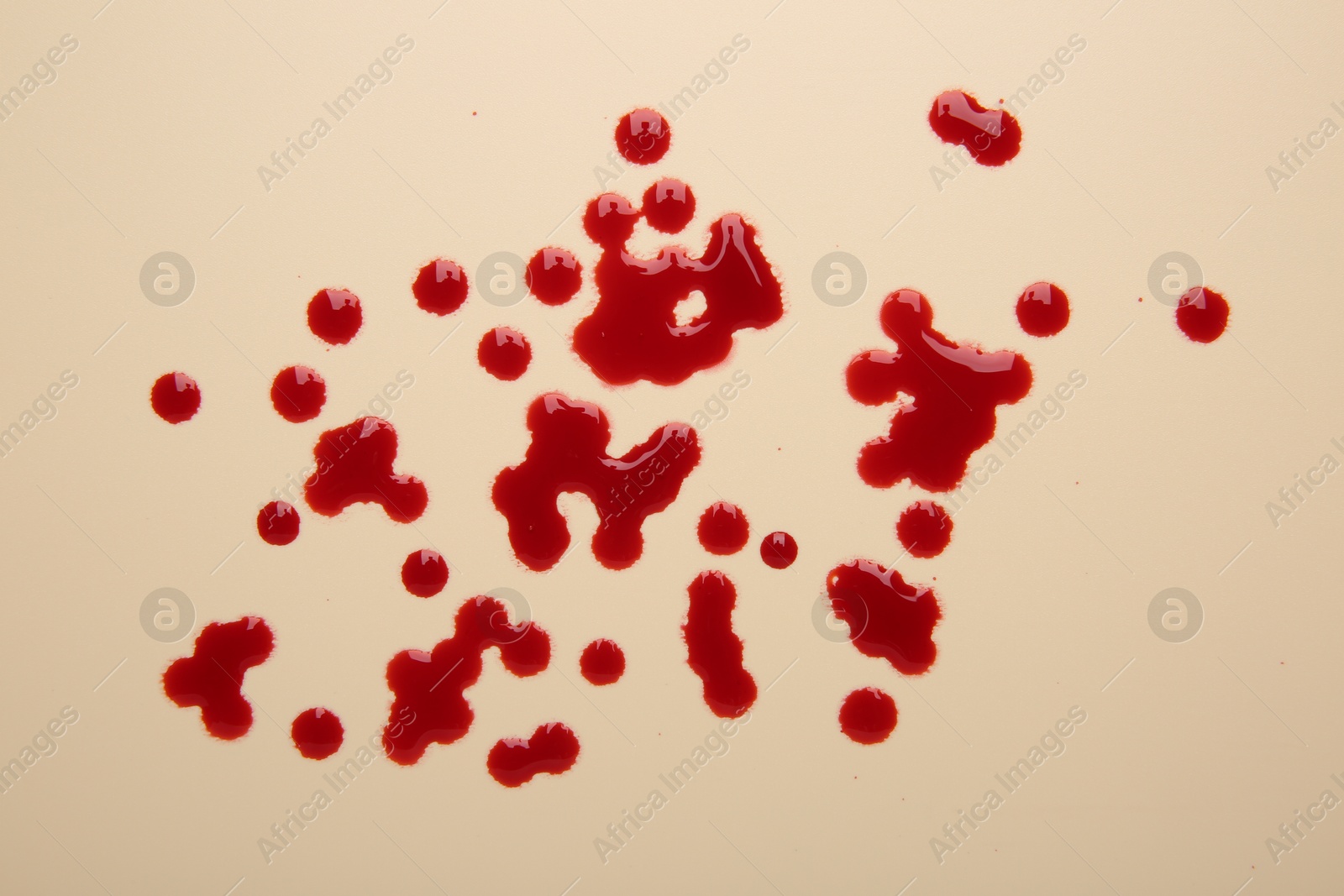 Photo of Drops of blood on beige background, top view